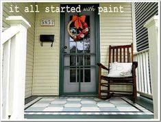 a rocking chair sitting on the front porch of a house with it's door painted white