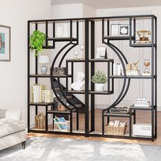 a living room filled with furniture and a book shelf next to a white couch on top of a hard wood floor