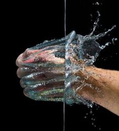 a person's hand with water splashing out of it