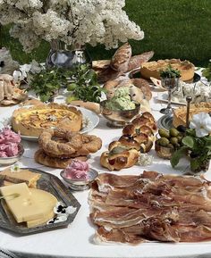 a table filled with lots of different types of food on plates and serving trays