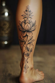 a close up of a person's leg with flowers on it and a tattoo