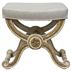 an ornate bench with a white cushion on it's back and gold trimmings