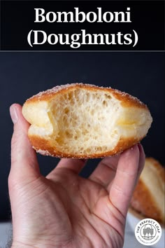 a person holding a piece of bread in their hand with the words bomboloni doughnuts above it