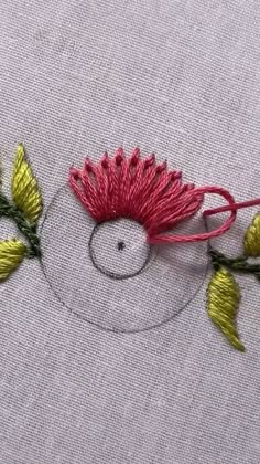 a close up of a piece of cloth with flowers on it and thread in the middle