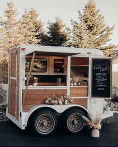 the food truck is decorated with flowers and chalkboard writing on it's side