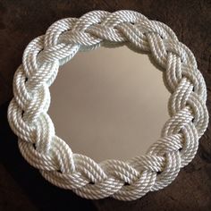 a white rope mirror hanging on a wall