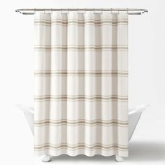 a white shower curtain with brown and beige stripes on the bottom, in front of a white bathtub