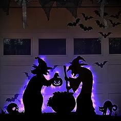 two halloween silhouettes in front of a garage with bats and pumpkins on it