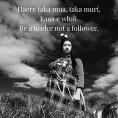 a woman standing in tall grass with a quote above her that says, here tata maa, taka muri, kaua e whati be a leader not a follower