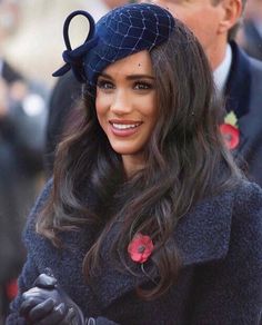 a woman with long hair wearing a blue hat and gloves on her head is smiling at the camera