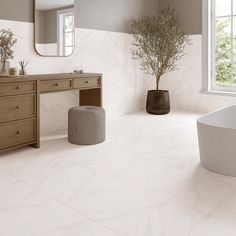 a bathroom with a tub, sink and large mirror on the wall next to it