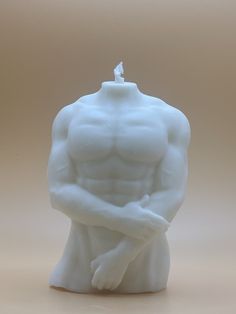 a white candle with a man's torso and arms in the shape of a body