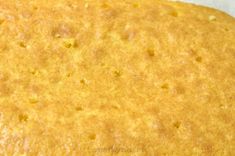 a yellow cake is sitting on top of a white tablecloth with holes in it