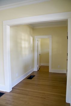 an empty room with hard wood flooring and white trim on the walls is seen in this image