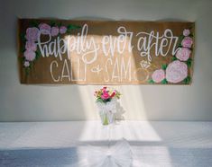 a sign that says happily ever after cali and samo with flowers on it