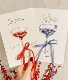 two handmade greeting cards with wine glasses on them, tied together in red and blue ribbon