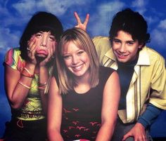 three young people sitting next to each other with their hands on their faces and looking at the camera