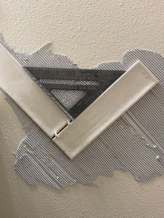 a piece of duct taped to the side of a wall with scissors stuck in it