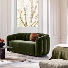 a living room with green velvet furniture and white walls