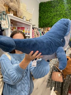 a woman is holding up a stuffed animal