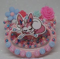 a close up of a pink and blue ring with an animal sticker on it