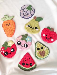 an assortment of embroidered fruits and vegetables on a white cloth background, including apples, watermelon, pineapple, peaches, kiwi