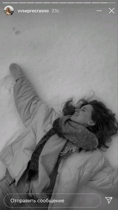 a woman laying in the snow with her feet up