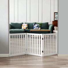 a living room with a green couch and white fenced in area next to it