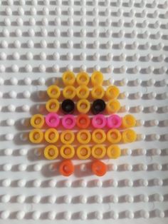 a lego bird made out of different colored plastic rings on a white surface with black and yellow circles