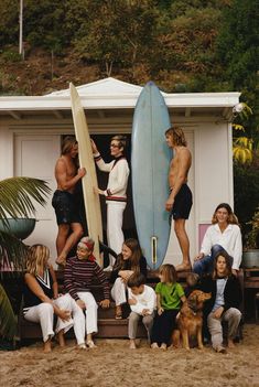 a group of people standing around each other holding surfboards