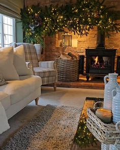 a living room filled with furniture and a fire place covered in christmas garlands on the wall