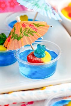 there is a small bowl with jelly bears in it and an umbrella on the table