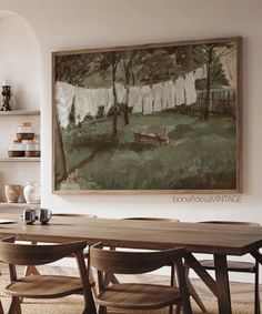 a painting hanging on the wall above a dining room table