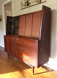 a wooden cabinet with two drawers and a television on it's stand in a living room