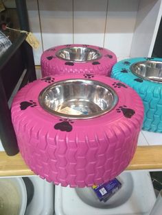 three pink and blue dog bowls sitting on top of each other in front of a mirror