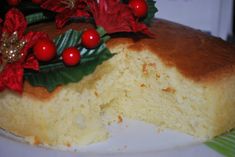 a close up of a cake on a plate with holly and red berries around it