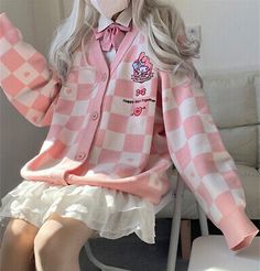 a doll sitting on top of a chair wearing a pink and white checkered shirt