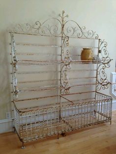 a metal rack with shelves on top of it in a living room next to a wall