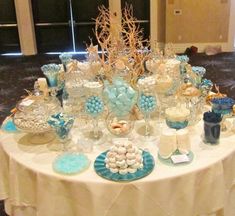 a table topped with lots of blue and white desserts