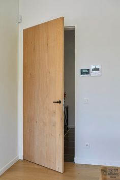 an open wooden door in a white room