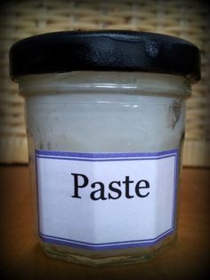 a jar filled with paste sitting on top of a wooden table