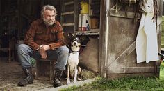 a man sitting on a bench next to a dog