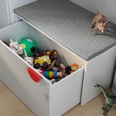 a toy box with toys in it and a cat on the floor