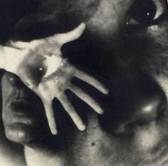 a black and white photo of a person holding their hand up to his face with both hands