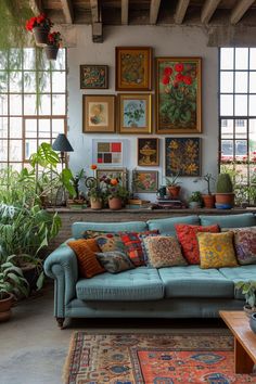 a living room filled with lots of potted plants and pictures on the wall above it