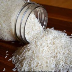 white rice spilling out of a jar onto a wooden table