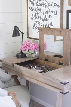 a desk with a mirror and flowers on it