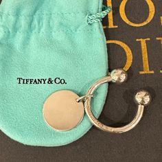 a tiffany & co keychain is laying on top of a bag