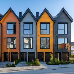 a row of multi - colored houses with black garage doors