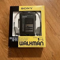 a sony walkman with headphones in its packaging on a wooden table, ready to be used